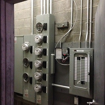 Multi-meter electrical room with conduit and breaker panel.
