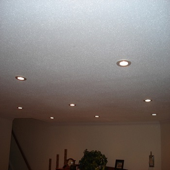 Living room recessed lighting installed in finished ceiling.