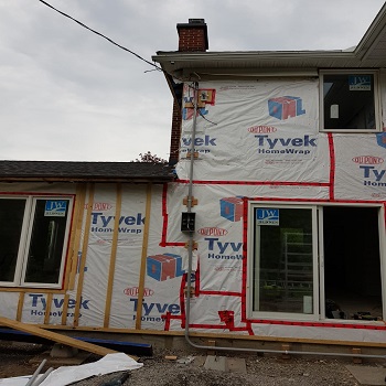 Home renovation with exterior conduit and Tyvek wrap.