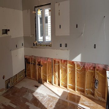 Kitchen renovation showing exposed wiring and insulation.