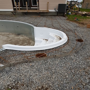 Inground pool construction with steel rebar and pool shell installation.