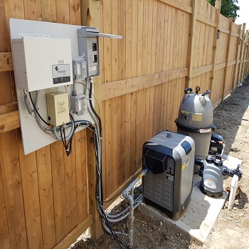 Pool equipment pad with heater, pump, and electrical controls installed.