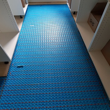 Radiant floor heating system with blue membrane and heating cables.