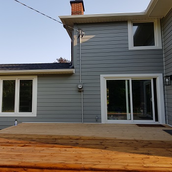 Home exterior with new siding, electrical conduit, and sliding door.