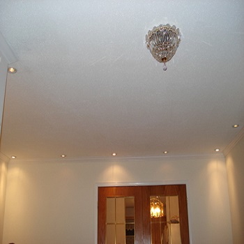 Ceiling with recessed lights and a central decorative chandelier.