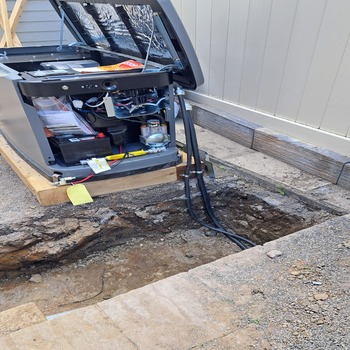 Standby generator installation with underground electrical conduit trench.